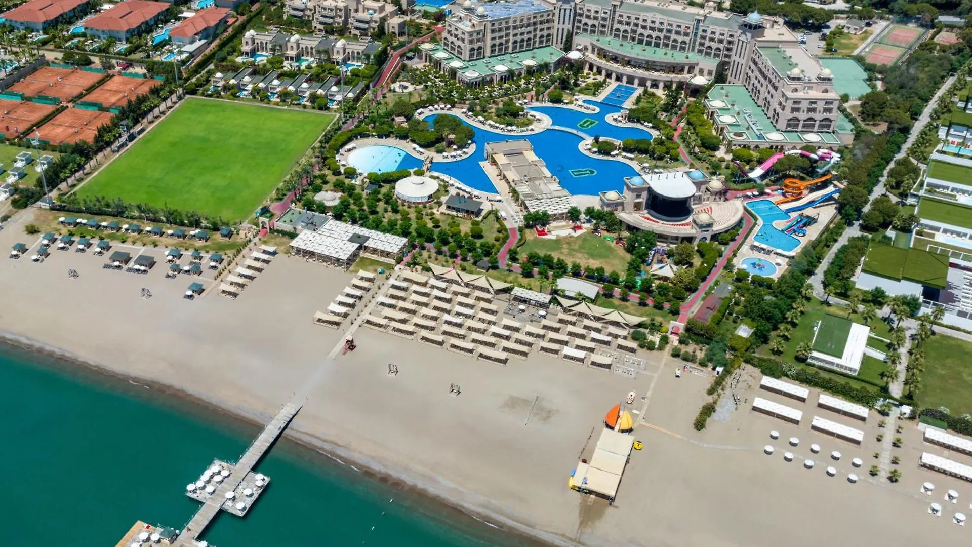 Spice Hotel & Spa Belek Exterior photo This is an aerial photograph showcasing a large, luxurious resort complex situated along a beautiful beach.

**Key features visible in the photo include:**

*   **The Resort:** The main part of the resort features multiple large buildings with light-